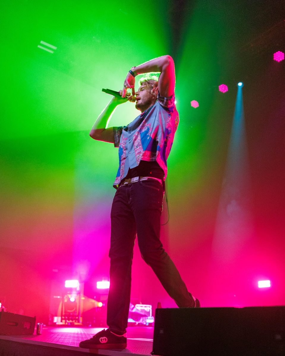 Yung Gravy performing with green stage lighting from above and red from below clashing in the middle